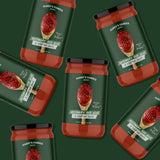 Multiple jars of 'Harry's Famous' rosemary red wine starter sauce on a green background