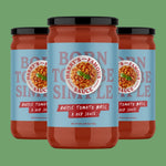 Three jars of 'Harry's Famous' rustic tomato basil sauce on a green background